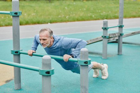 Photo for Full length portrait of active mature man doing push ups during outdoor workout in city - Royalty Free Image