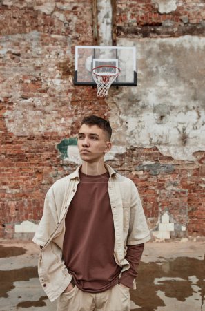 Photo for Neutral waist up portrait of young man wearing street style fashion against shabby brick wall - Royalty Free Image