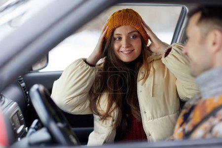 Téléchargez les photos : Portrait de jeune femme souriante en voiture avec petit ami, prêt pour une escapade hivernale ensemble - en image libre de droit