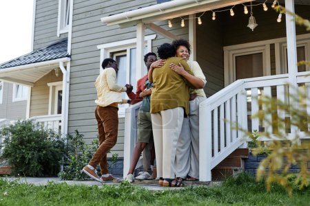 Photo for Full length portrait of happy black family embracing on porch of new house, copy space - Royalty Free Image