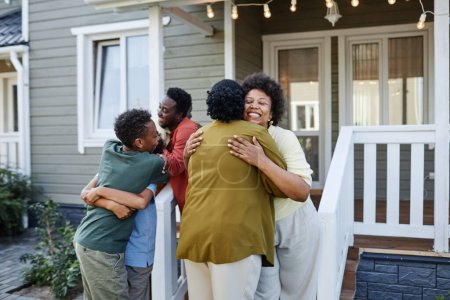 Foto de Gran familia afroamericana abrazando al aire libre dando la bienvenida a los invitados para la fiesta de inauguración - Imagen libre de derechos