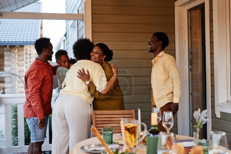 Téléchargez les photos : Portrait de famille afro-américaine embrassant à l'extérieur accueillant invités pour la fête de la maison - en image libre de droit