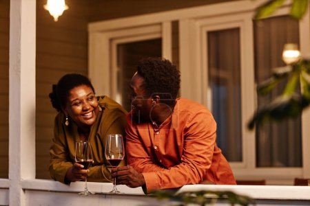 Foto de Retrato de pareja afroamericana charlando en la terraza de la casa por la noche - Imagen libre de derechos