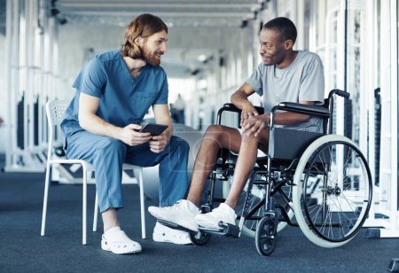 Téléchargez les photos : Médecin en uniforme discutant de l'entraînement sportif avec un patient assis en fauteuil roulant et l'écoutant - en image libre de droit