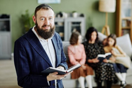 Porträt eines bärtigen Juden, der Kippa trägt und in die Kamera blickt, Buch in der Hand, Kopierraum