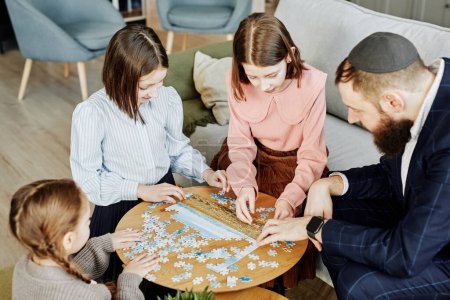Photo for High angle view at jewish family playing puzzle game together at home - Royalty Free Image
