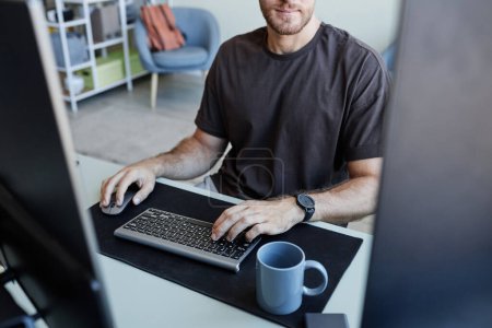 Foto de Primer plano del joven hombre caucásico escribiendo en el teclado mientras que el software de programación, espacio de copia - Imagen libre de derechos
