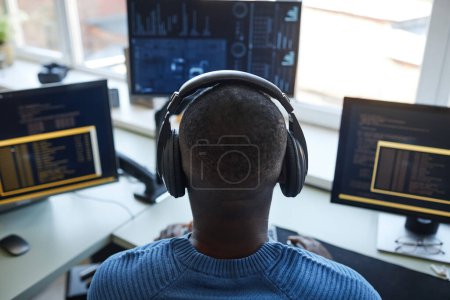 Téléchargez les photos : Portrait arrière du développeur de logiciels au poste de travail avec plusieurs écrans d'ordinateur - en image libre de droit