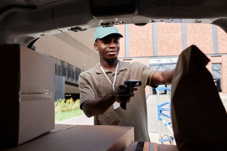 Photo for Portrait of delivery man scanning codes on packages while unloading van, copy space - Royalty Free Image