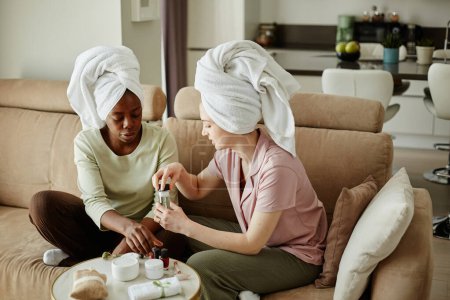 Photo for Portrait of two girls with towels doing manicure while enjoying beauty day at home - Royalty Free Image