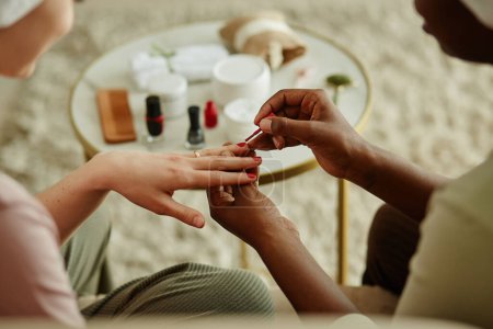 Photo for Close up of two young women with towels doing manicure at home while enjoying self care day - Royalty Free Image