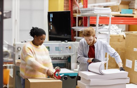 Téléchargez les photos : Portrait de deux ouvriers ouvrant des boîtes avec du papier dans une imprimerie industrielle, espace de copie - en image libre de droit