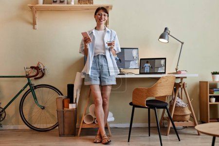 Téléchargez les photos : Portrait complet de la jeune femme créative en tant que designer 3D regardant la caméra par lieu de travail de bureau à domicile - en image libre de droit