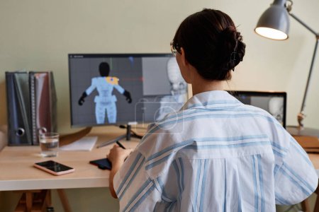 Téléchargez les photos : Vue arrière du designer féminin construisant des modèles 3D et utilisant l'ordinateur au bureau à domicile - en image libre de droit