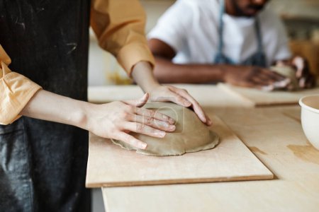 Téléchargez les photos : Gros plan de la jeune femme façonnant bol en céramique fait à la main dans un studio de poterie confortable, espace de copie - en image libre de droit