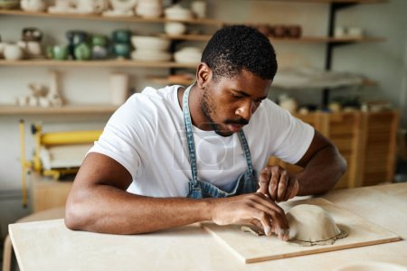 Photo for Warm toned portrait of creative black man shaping ceramic bowl in cozy pottery studio - Royalty Free Image