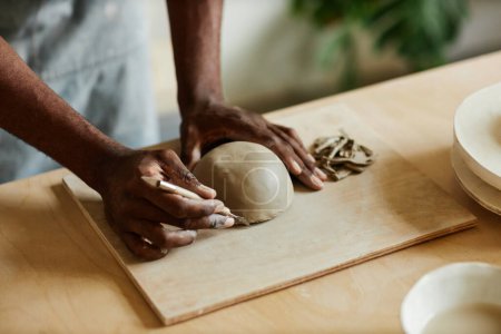 Téléchargez les photos : Gros plan chaleureux de l'artiste masculin créant un bol en céramique fait à la main dans un atelier de poterie, espace de copie - en image libre de droit