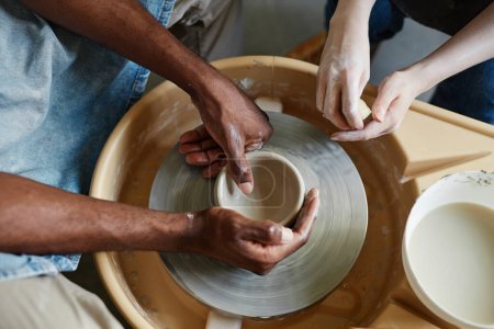 Foto de Vista superior de la pareja joven utilizando la rueda de cerámica juntos y la creación de cerámica hecha a mano - Imagen libre de derechos