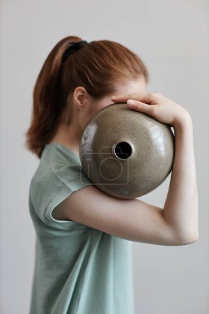 Téléchargez les photos : Concept portrait de jeune femme tenant vase en céramique fait main - en image libre de droit