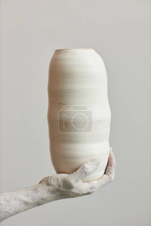 Photo for Closeup of hand holding handmade ceramic vase, art and artist concept - Royalty Free Image