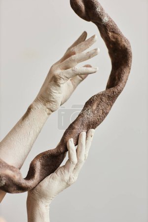 Photo for Close up of elegant hands covered in paint holding ceramic art piece minimal - Royalty Free Image