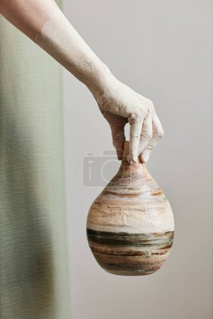 Photo for Minimal concept shot of female hand holding testured ceramic piece - Royalty Free Image