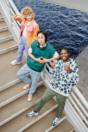 Photo for Graphic top view of diverse young people on stairs looking up with water in background - Royalty Free Image