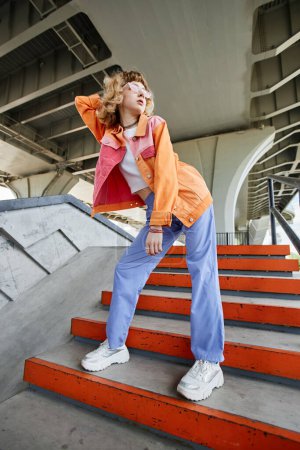 Téléchargez les photos : Portrait de jeune femme insouciante portant un style de rue coloré à l'extérieur en milieu urbain - en image libre de droit