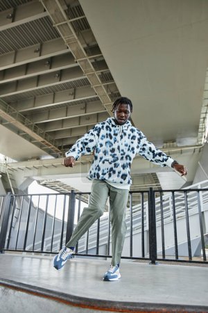 Foto de Retrato vertical de cuerpo entero del joven negro bailando al aire libre en la zona urbana - Imagen libre de derechos