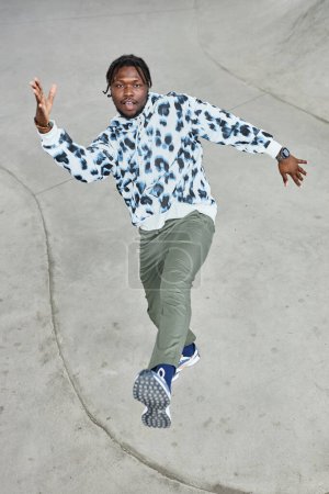 Photo for Vertical full length portrait of young black man dancing hip hop outdoors in urban area - Royalty Free Image
