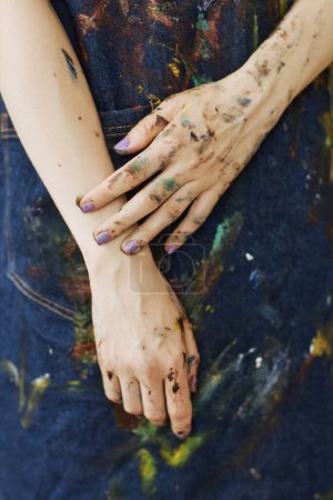 Téléchargez les photos : Gros plan des mains de la jeune créatrice peintre en tablier de denim debout devant la caméra pendant le travail sur un nouveau chef-d'œuvre - en image libre de droit