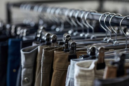 Foto de Cierre de jeans y pantalones en fila en el estante de ropa en la tienda de segunda mano, espacio para copiar - Imagen libre de derechos
