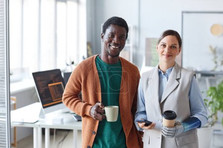 Foto de Retrato de empresarios positivos con tazas de café de pie en la oficina de la empresa de TI - Imagen libre de derechos