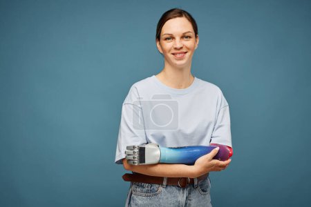 Photo for Studio portrait of positive young woman with bionic arm - Royalty Free Image