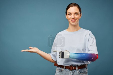 Téléchargez les photos : Joyeux jeune femme avec bras bionique montrant nouveau projet - en image libre de droit