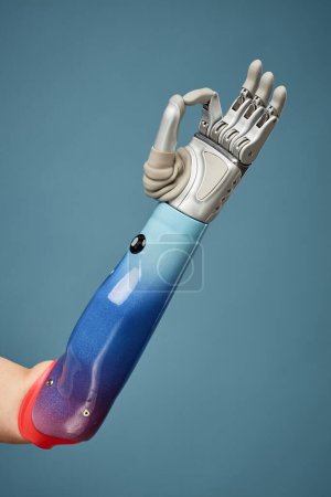 Photo for Prosthetic arm showing OK sign, isolated on blue, innovation and science development concept - Royalty Free Image