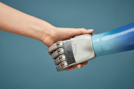 Photo for Closeup image of person shaking hand of robot, artificial intelligence concept - Royalty Free Image