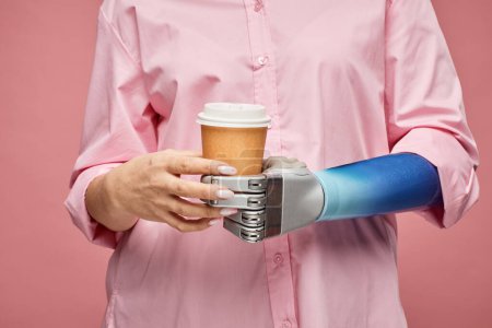 Photo for Closeup image of woman with bionic arm holding cup of take-out coffee - Royalty Free Image