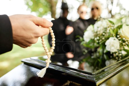Foto de Primer plano del hombre sosteniendo rosario y rezando en la ceremonia funeraria al aire libre, espacio para copiar - Imagen libre de derechos