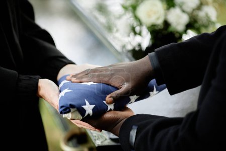 Foto de Primer plano de la entrega general de la bandera estadounidense doblada a la mujer en la ceremonia funeraria para veterano del ejército - Imagen libre de derechos