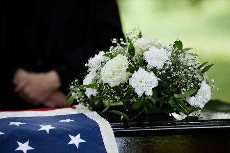 Téléchargez les photos : Gros plan du cercueil avec des fleurs lors de la cérémonie funéraire extérieure pour vétéran de l'armée, espace de copie - en image libre de droit