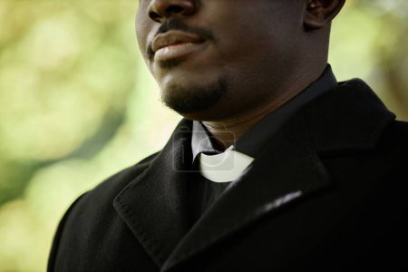 Photo for Close up of African American priest wearing black at outdoor funeral ceremony with focus on clerical collar, copy space - Royalty Free Image