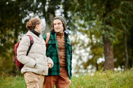 Téléchargez les photos : Portrait taille haute de jeune couple souriant profitant d'une promenade dans la forêt d'automne, espace de copie - en image libre de droit