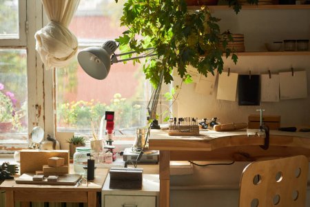 Foto de Imagen de fondo de taller de artesanía rústica en acogedor estudio en casa iluminado por la luz del sol y decorado con plantas - Imagen libre de derechos