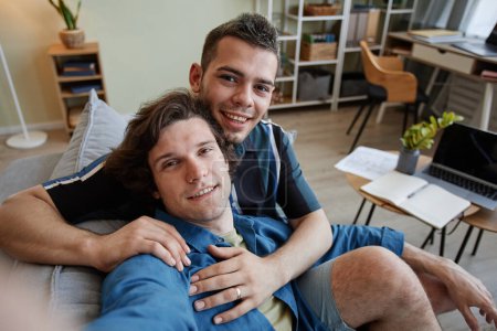 Foto de Retrato de joven pareja gay tomando foto selfie abrazando en nuevo hogar, cámara POV - Imagen libre de derechos