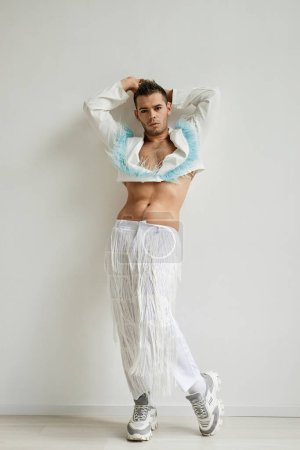 Photo for Vertical full length portrait of non binary man wearing crop top posing against white in fashion studio - Royalty Free Image