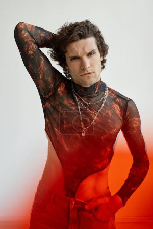 Foto de Retrato vertical del hombre no binario con corpiño de malla y posando sensualmente contra el blanco - Imagen libre de derechos
