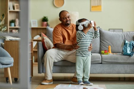 Photo for Full length portrait of cute black child wearing VR headset and enjoying virtual reality entertainment for children, copy space - Royalty Free Image