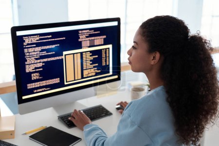 Photo for Serious female programmer writing code for testing computer software - Royalty Free Image