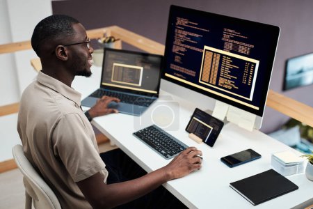 Foto de Desarrollador de software negro alegre examinando código escrito por compañeros de trabajo - Imagen libre de derechos